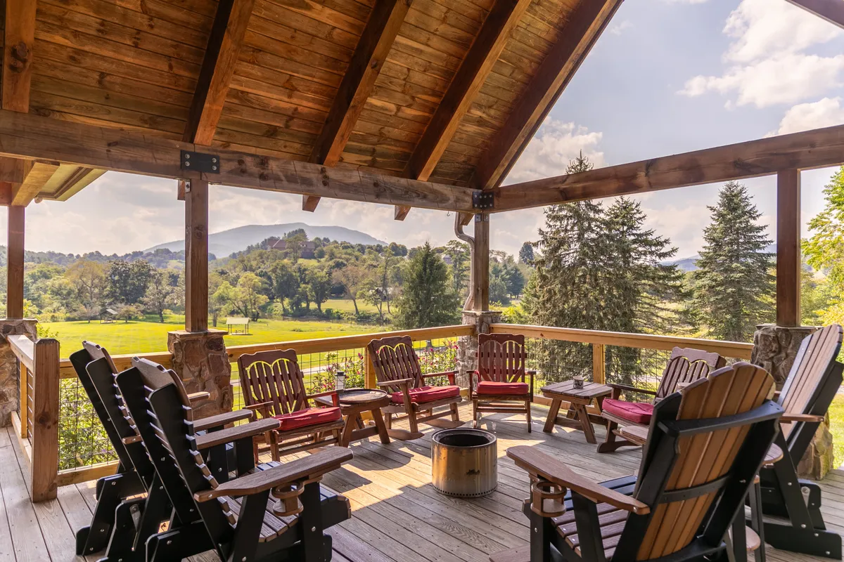 A spacious wooden deck equipped with a fire pit, surrounded by comfortable seating and nestled in breathtaking mountain scenery. The image suggests an ideal setting for communal gatherings, storytelling around the fire, and stargazing under the open sky.